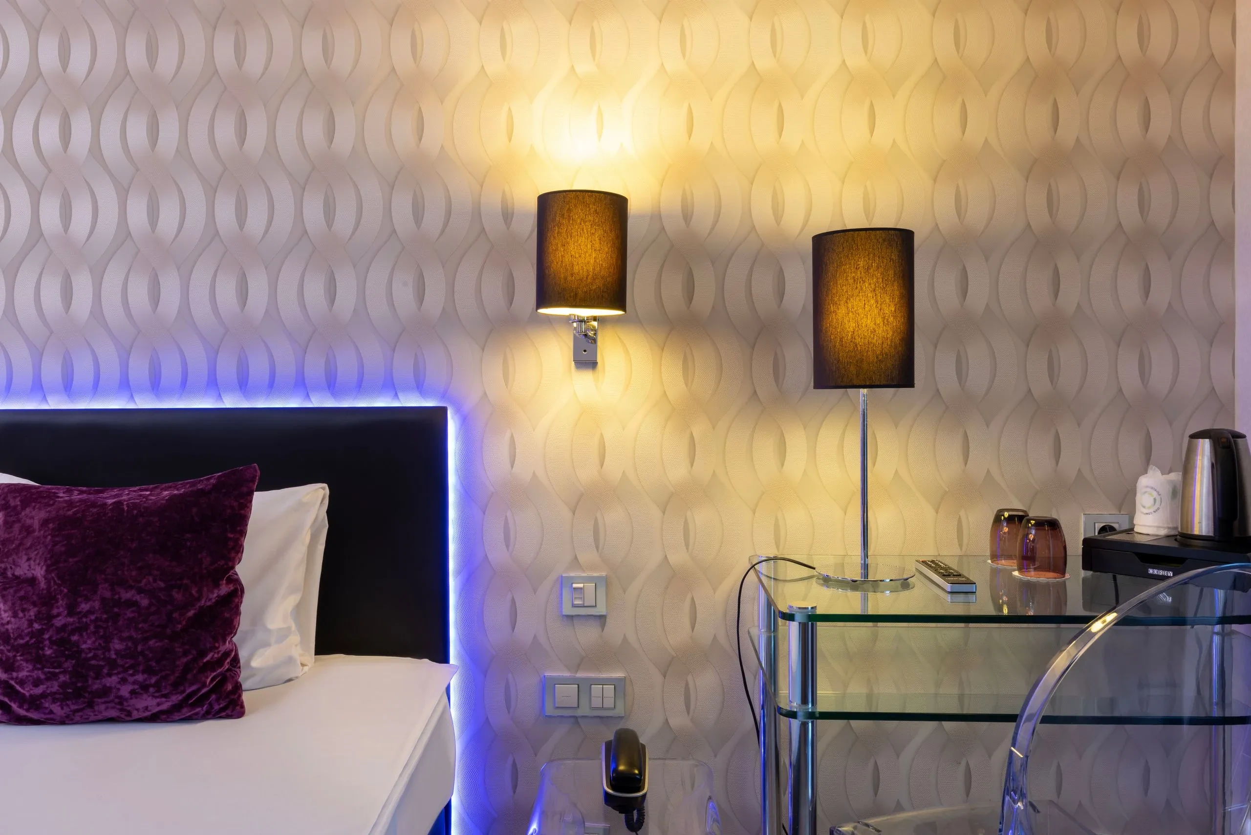 Chambre moderne avec lit et éclairage décoratif.