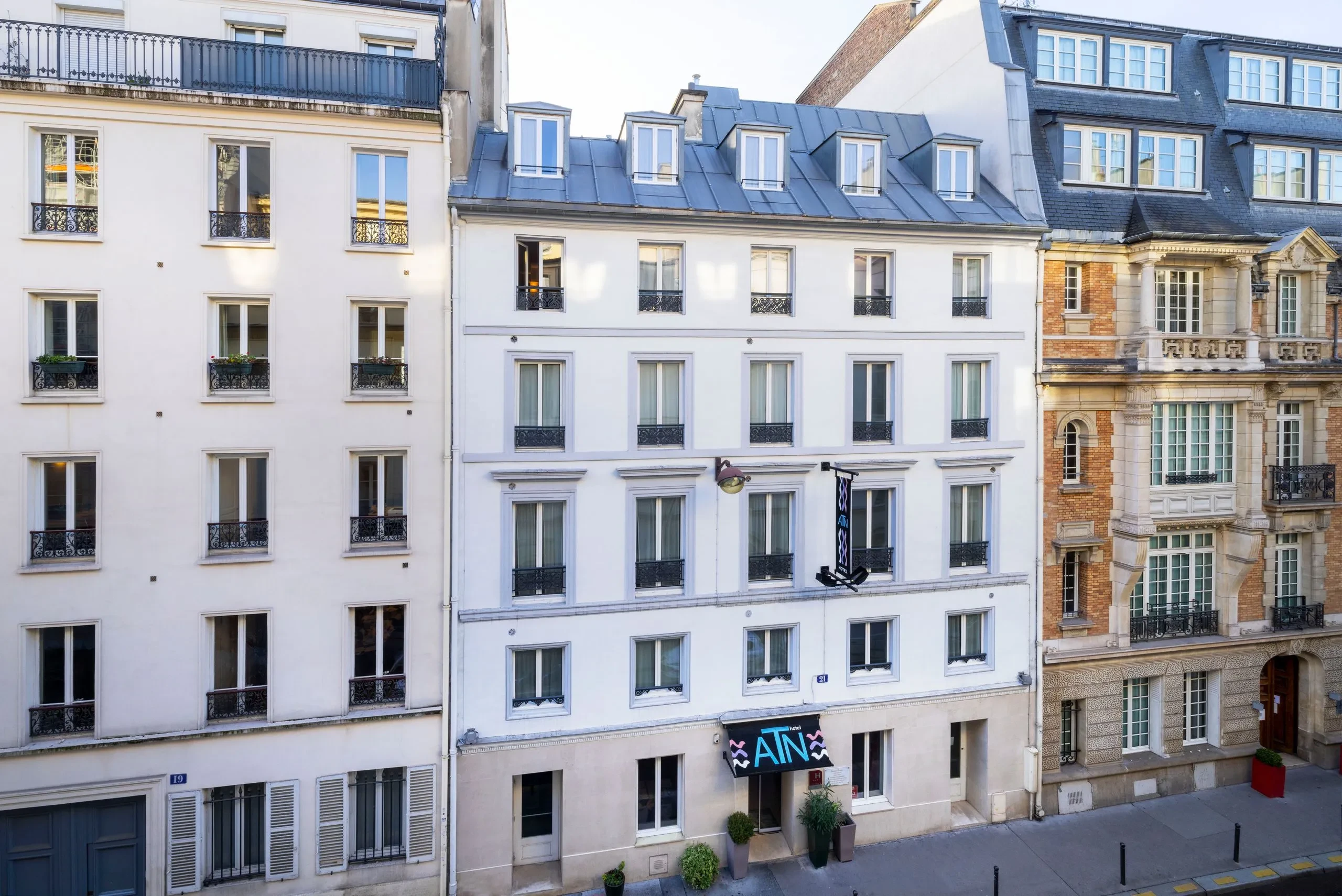 Façade d'immeuble parisien avec fenêtres et balcons.