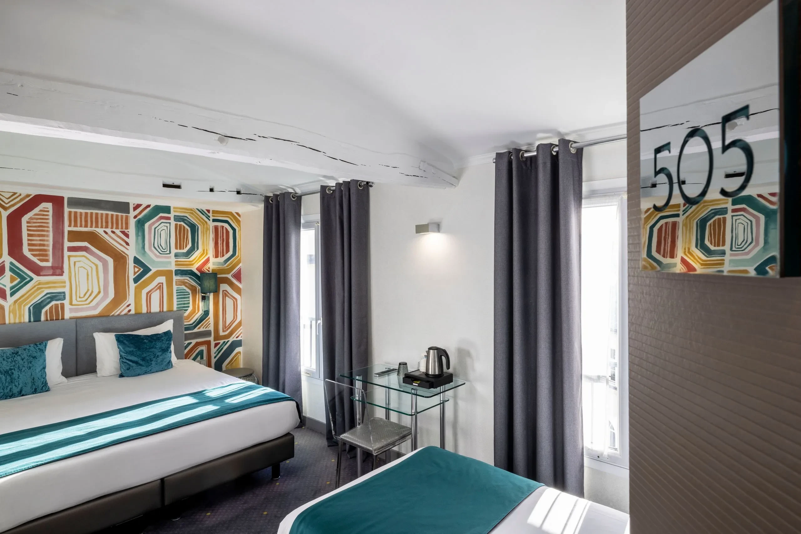 Chambre d'hôtel aux murs décoratifs colorés.