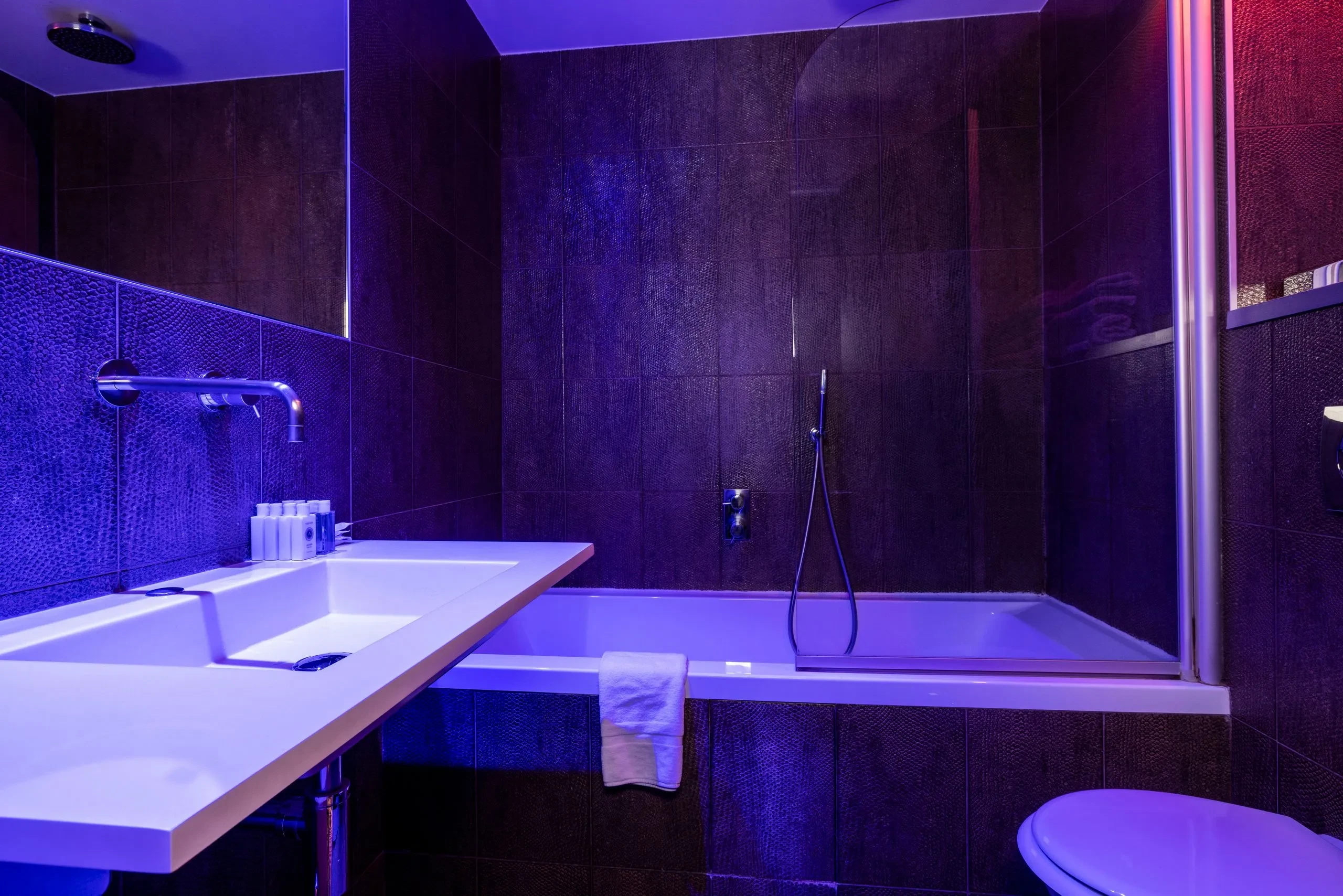 Salle de bain moderne avec éclairage violet.
