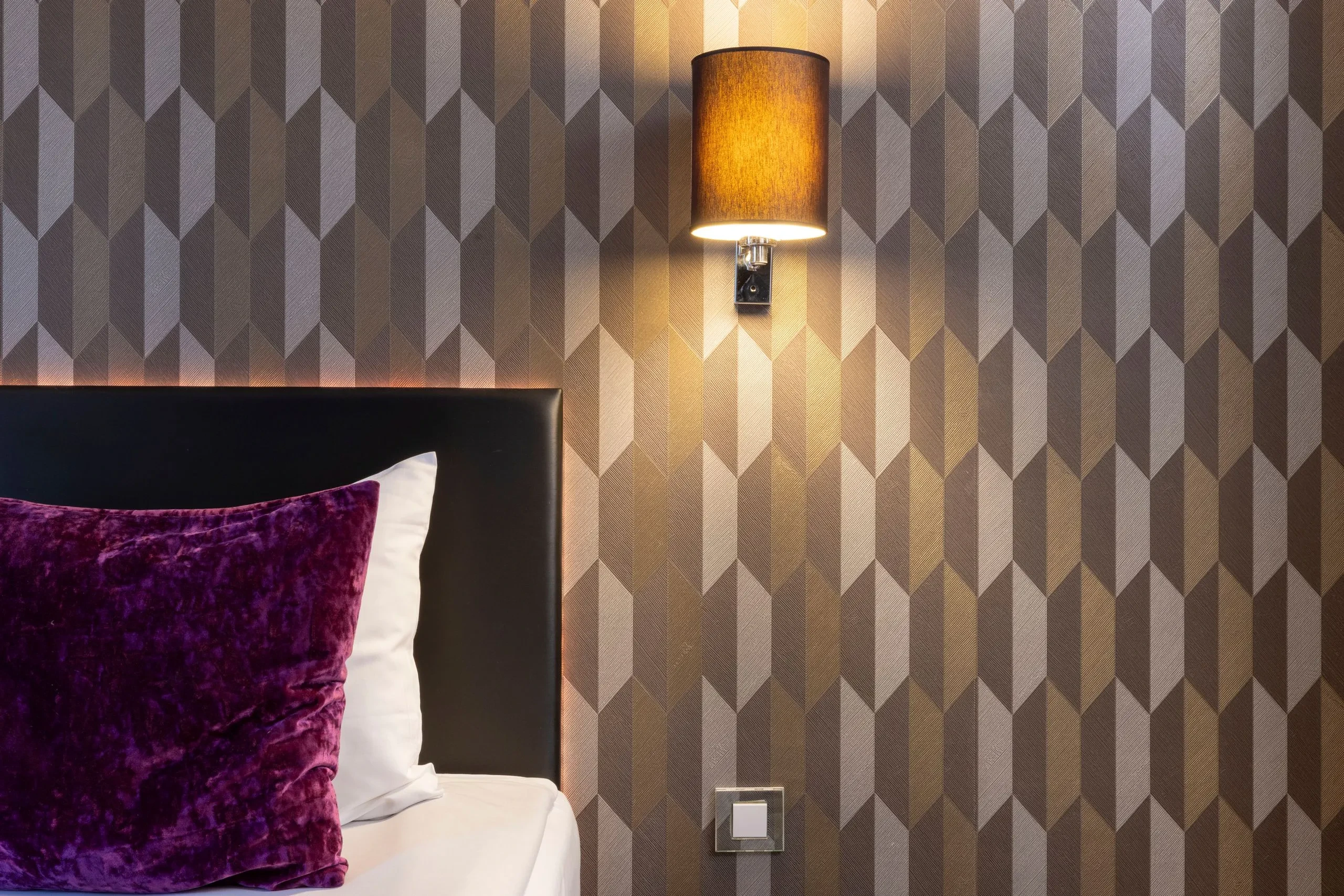 Chambre moderne avec lampe et coussin violet.