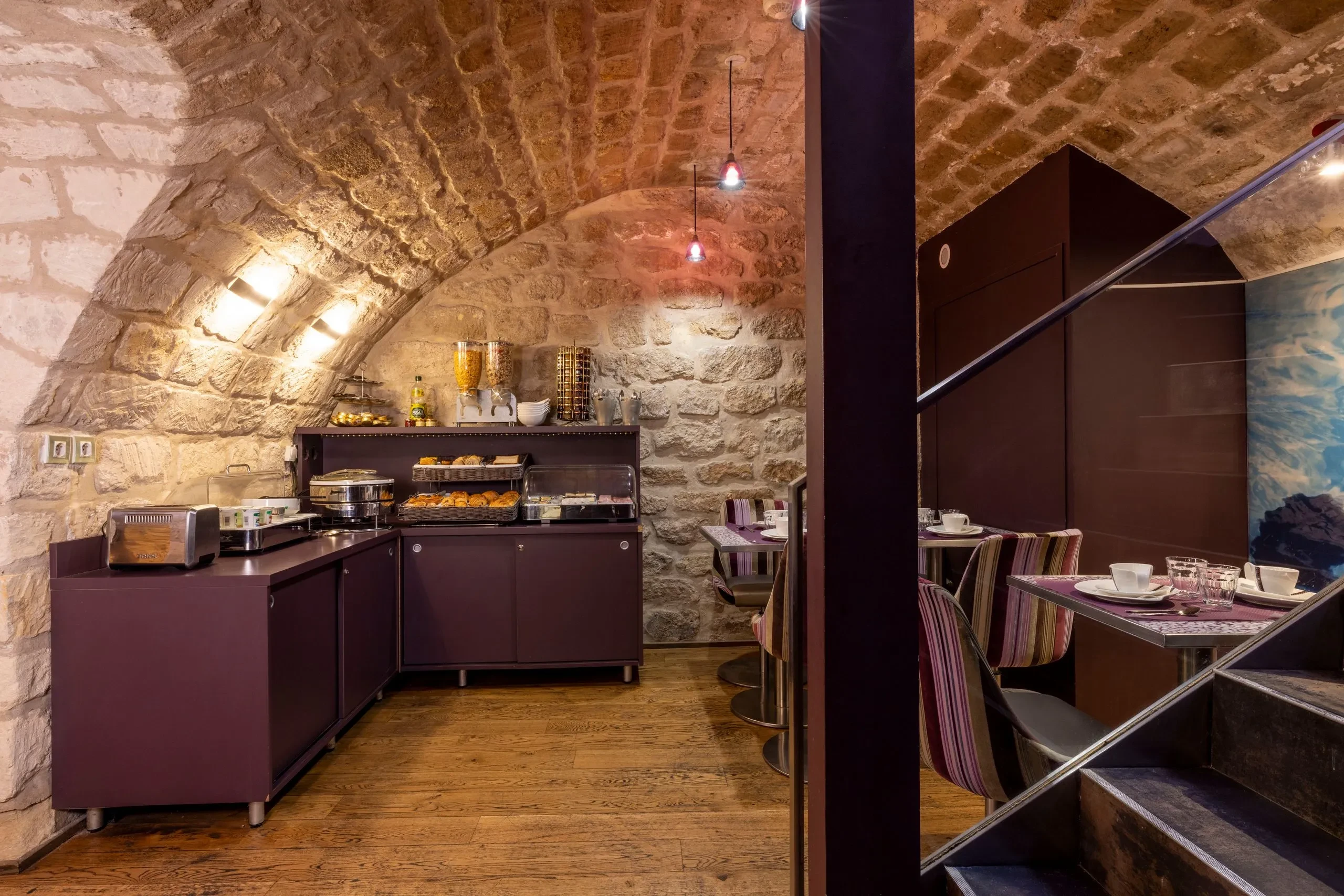 Salle de petit déjeuner voûtée en pierre.