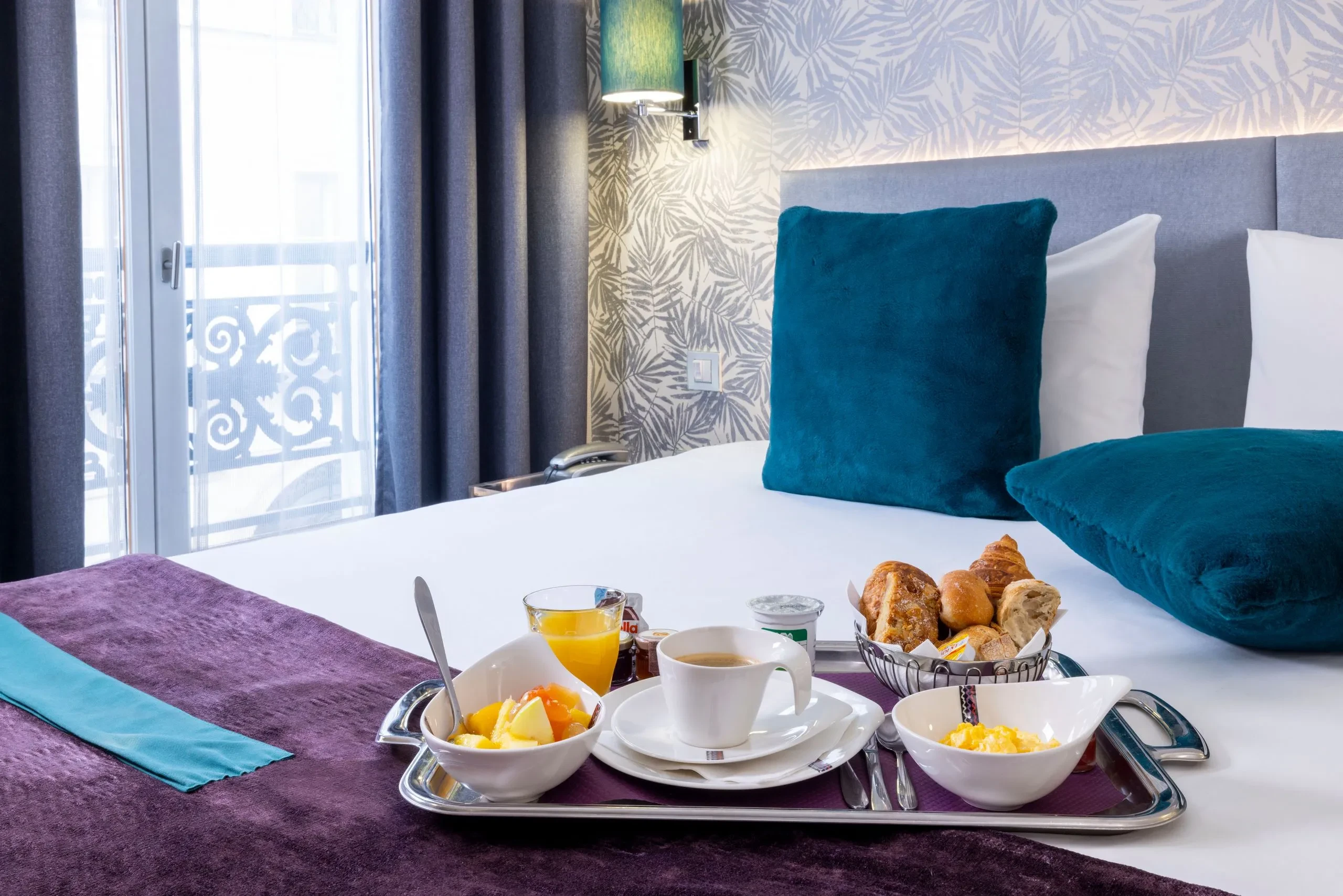 Petit déjeuner servi sur lit d'hôtel moderne.