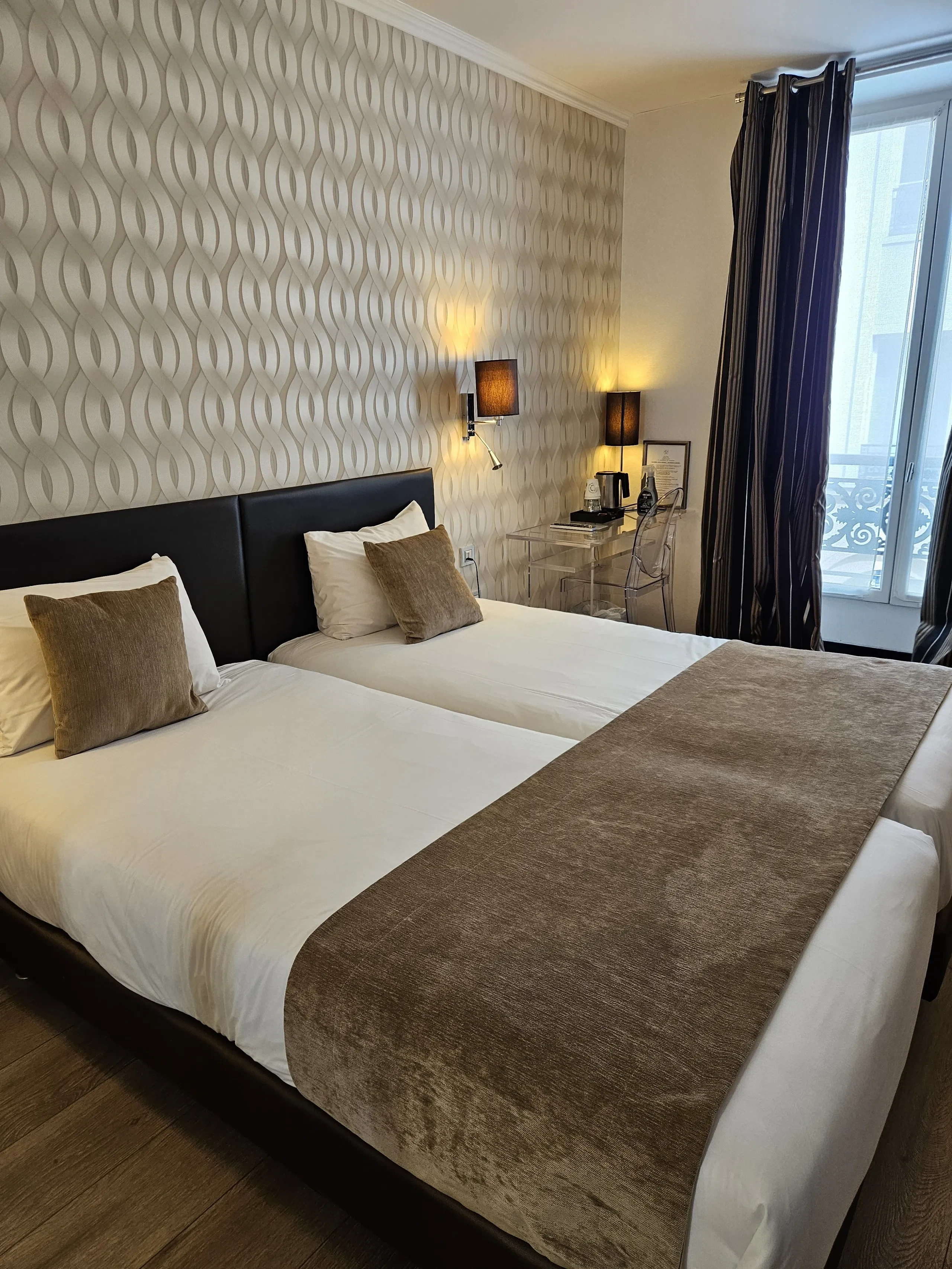 Chambre d'hôtel moderne avec deux lits simples.