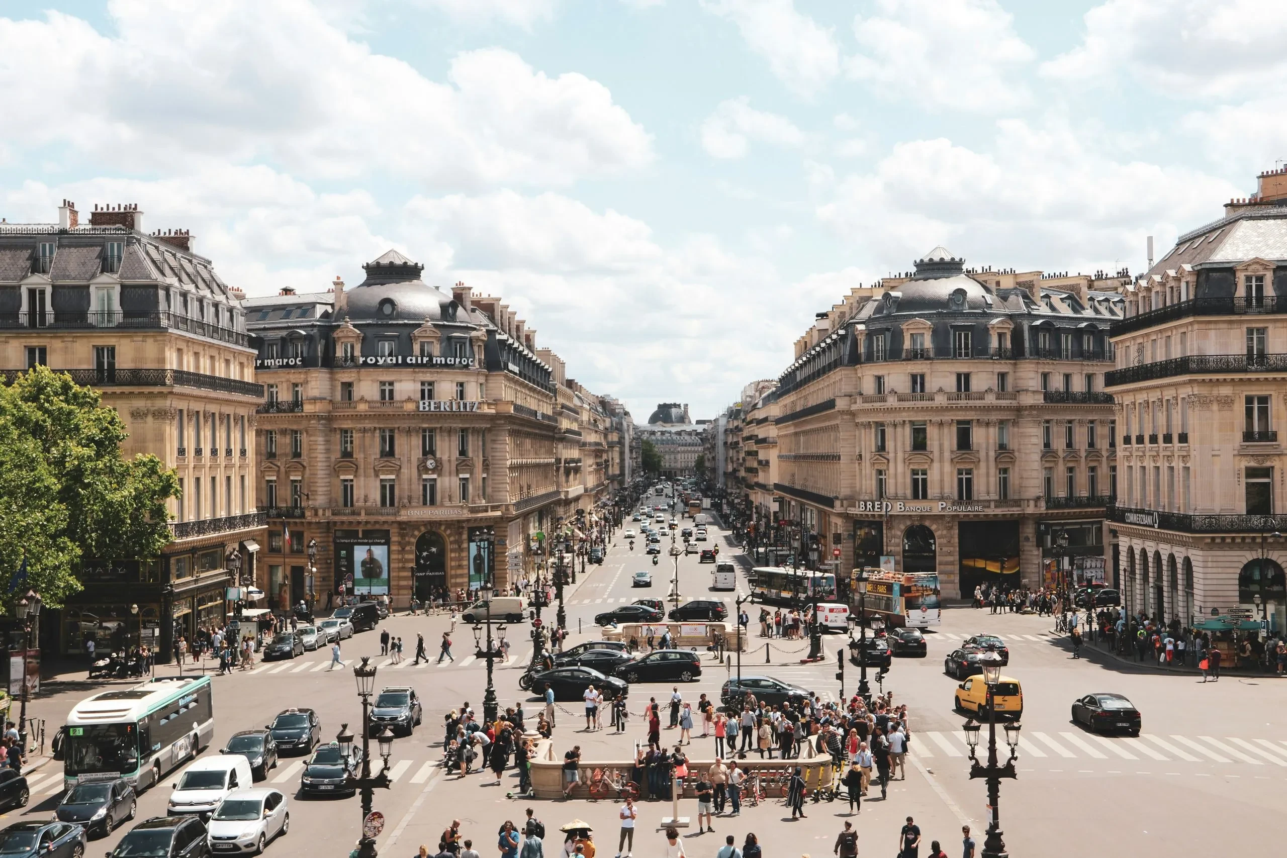 Vue animée de Paris avec bâtiments haussmanniens.